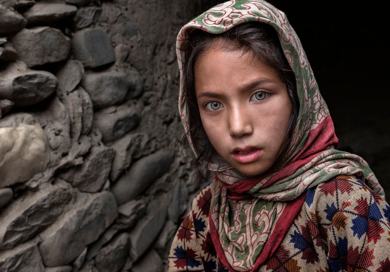 close up portrait of a young girl wearing a patterned headscarf lookin