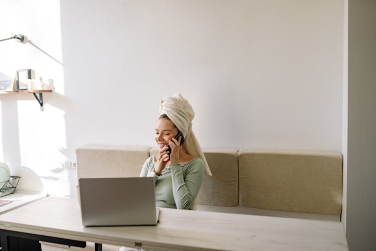 A Woman With A Head Towel Is Talking On Her Celphone