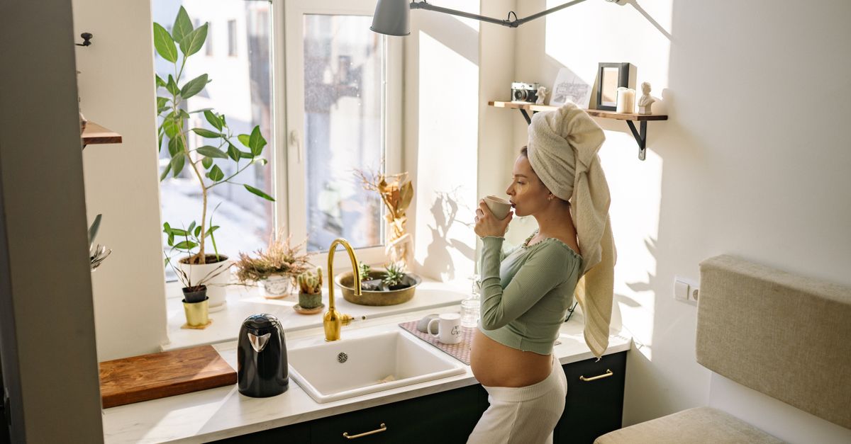 person drinking water in morning kitchen natural light