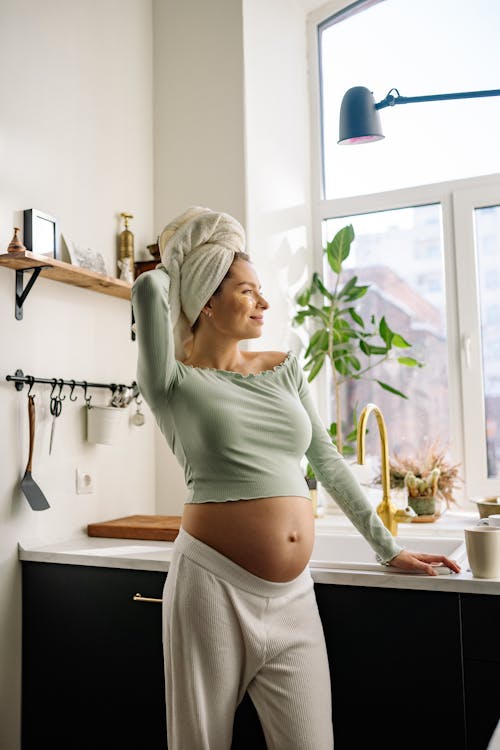 Free Pregnant Woman standing beside Kitchen Counter  Stock Photo