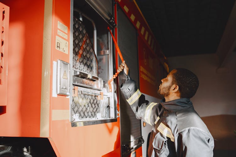 Fireman Securing A Ladder In The Firetruck