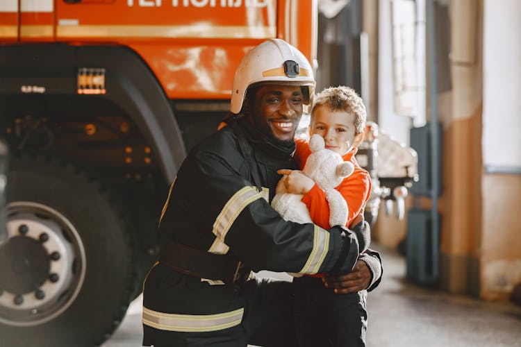 Fireman Embracing A Kid 