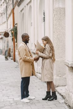 Smiling couple sharing a moment outdoors in winter clothing.