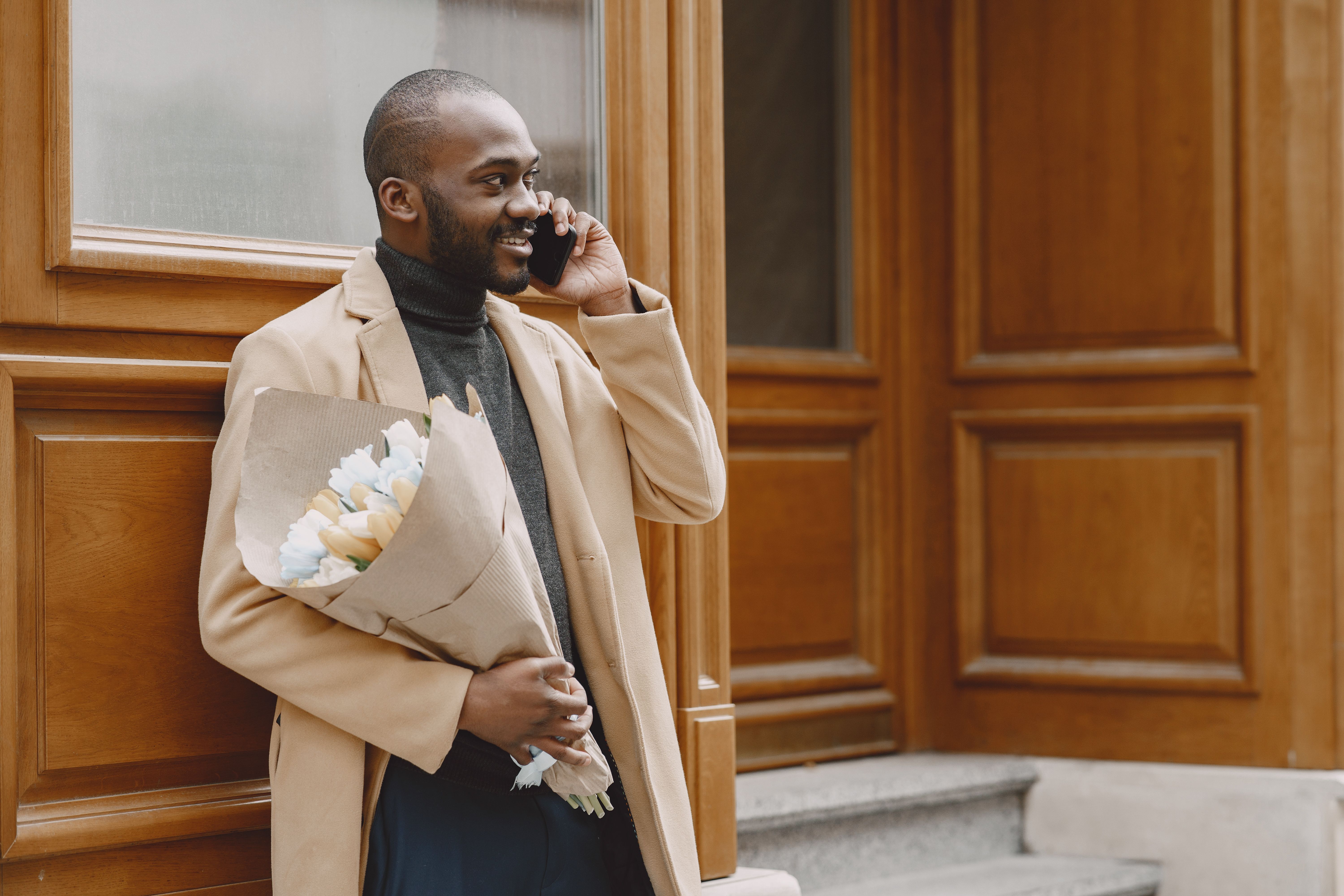 Man in Beige Coat carrying a Bouquet of Flowers · Free Stock Photo