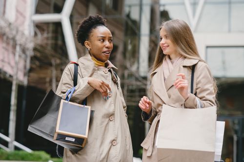 Free Two women shopping and having a conversation, embodying friendship and diversity. Stock Photo