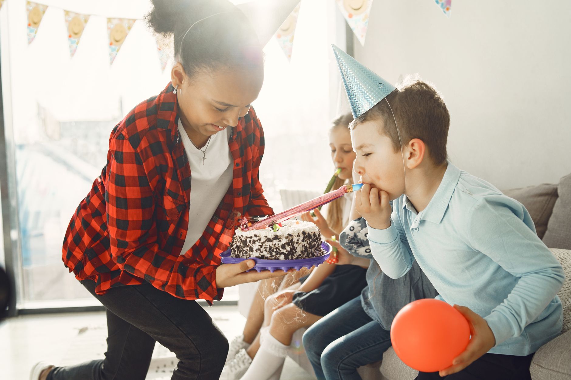 birthday cake and entertainment package cairo — Children celebrating a birthday indoors with cake and party decorations.