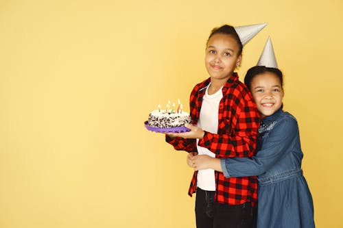 Free A Girl Hugging Her Sister Holding the Cake Stock Photo