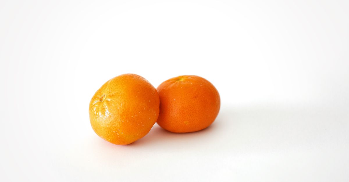 Close-up of fresh mandarin oranges on a clean white background, highlighting their vibrant color and texture. - Evidence evidence guide for tangerine peel skin health randomized trial