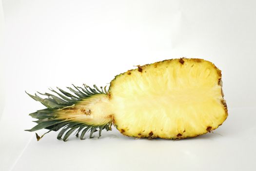 Close-up of a sliced pineapple on a white backdrop, showcasing fresh and healthy food.