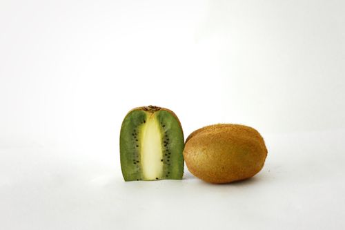 Free Studio shot of a fresh kiwi fruit, featuring a whole kiwi and a sliced kiwi exposing vibrant green flesh. Stock Photo