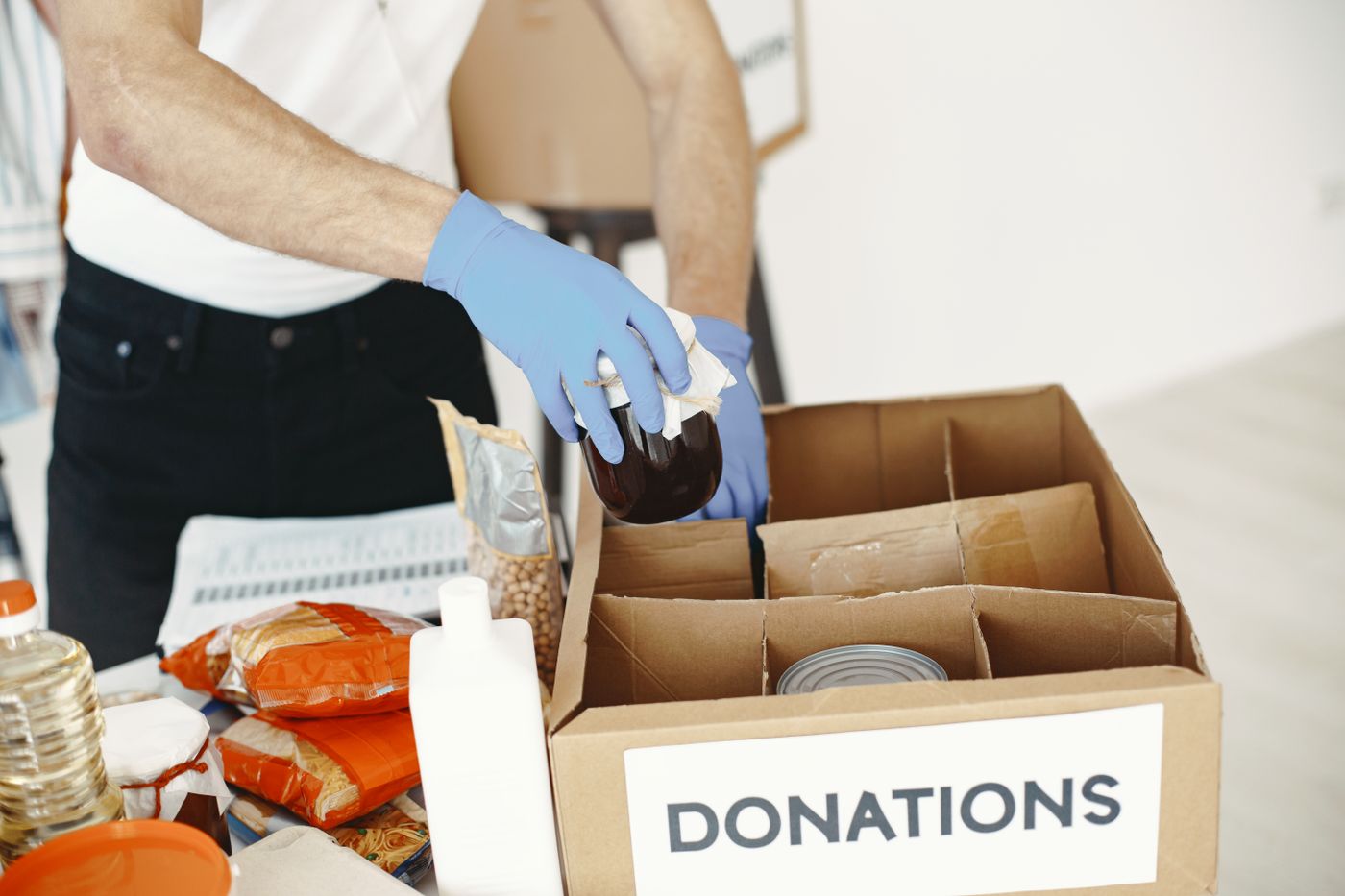 Volunteer packing canned food and supplies into a donation box