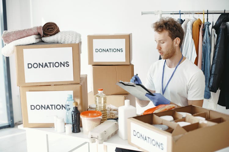 Charity Worker Checking Donation Boxes 