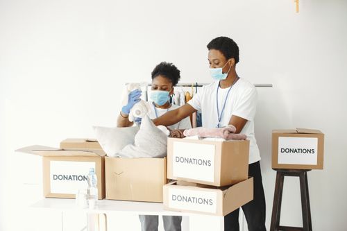 Free Group of volunteers packing donations for a charitable organization indoors. Stock Photo