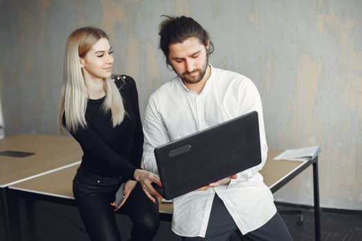 Two young professionals engaging in a collaborative discussion in a modern office setting.
