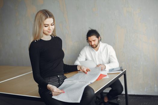 Two colleagues reviewing documents in a modern office setting, focused and professional.