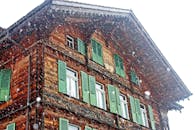 冬日白雪皑皑，因特拉肯的木制瑞士小屋配有绿色百叶窗