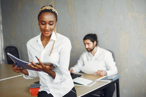 Free A friendly, collaborative environment featuring two professionals in an office setting. Stock Photo