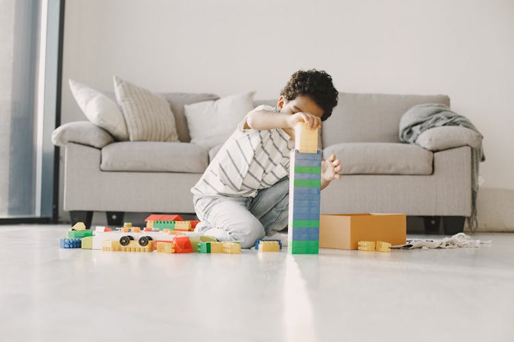 Little Boy Building With Blocks In A Living Room 