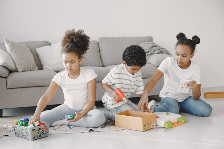 A Group Of Kids Playing Toys On The Floor