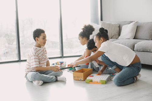 Free A group of children engaging in play with toys and games on a sunny day indoors. Stock Photo