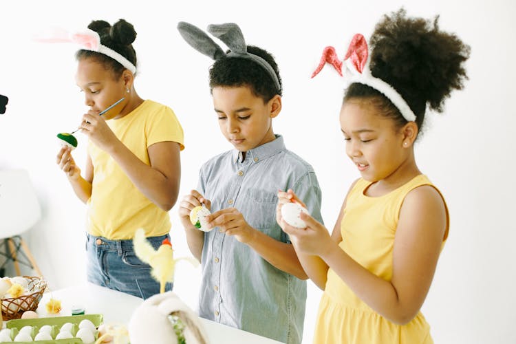 A Group Of Kids Painting Easter Eggs