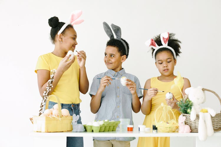 A Group Of Kids Painting Easter Eggs