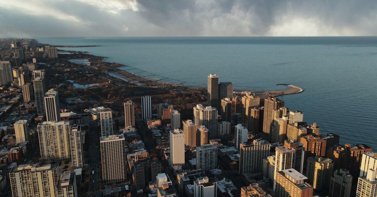 Stunning aerial view of Chicago skyscrapers and Lake Michigan under dramatic skies.