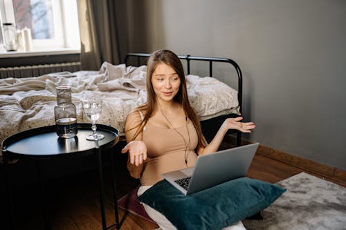 Free Woman Sitting on the Floor While Using Her Laptop  Stock Photo