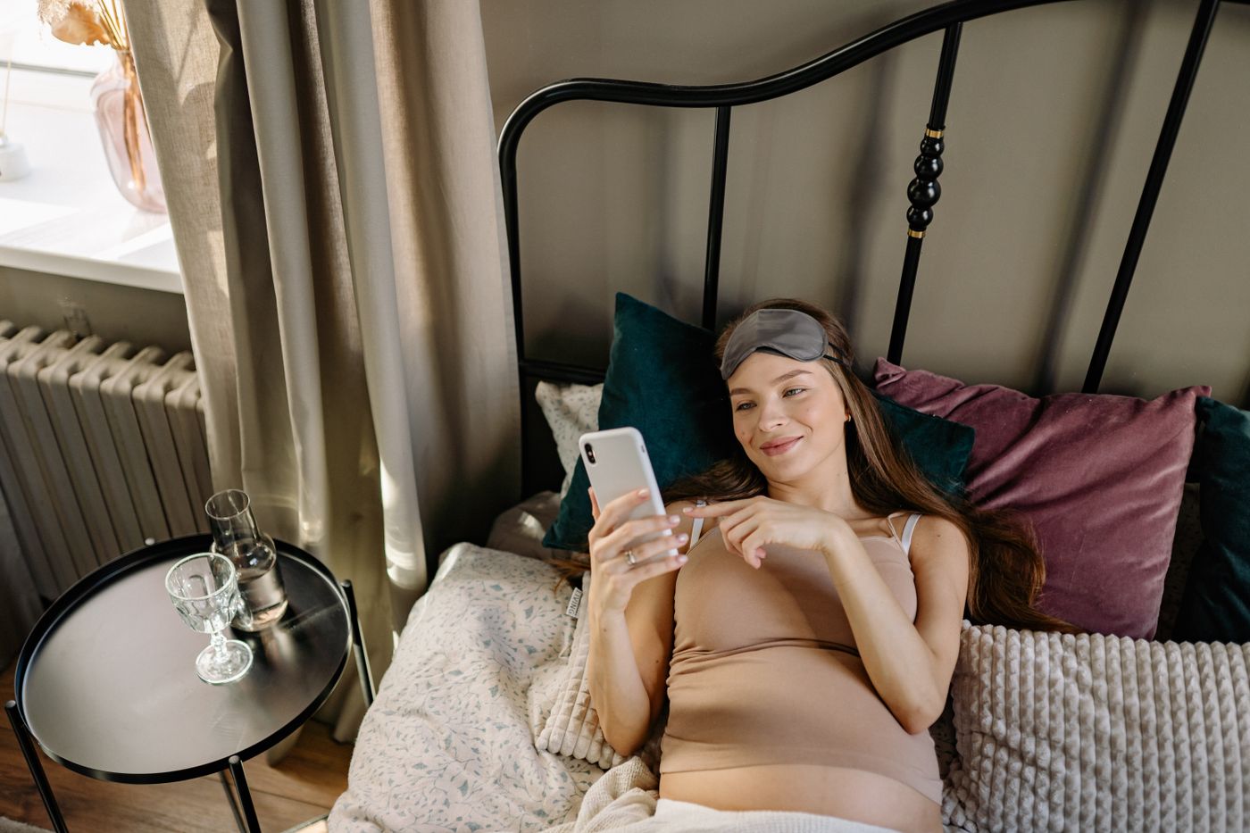Future maman allongée confortablement dans son lit pendant un moment de repos