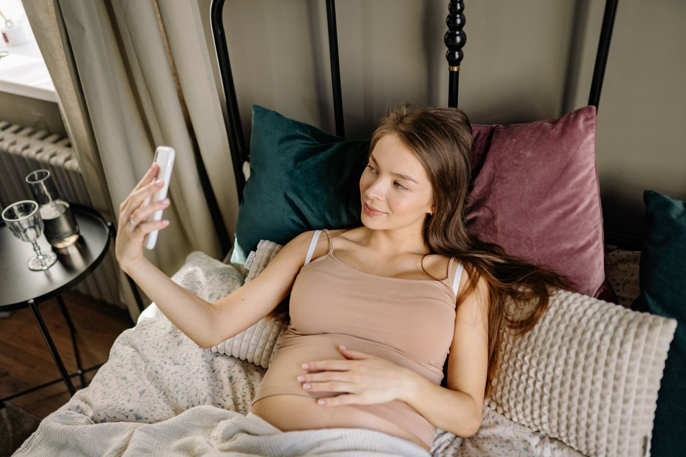 Femme enceinte installée sur le côté dans un lit lumineux pour se reposer confortablement