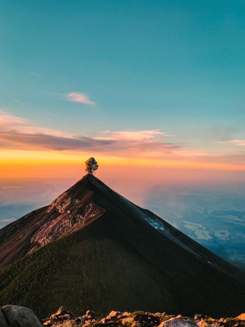 Free A breathtaking view of a volcanic mountain with a glowing sunrise in the background, captivating nature lovers. Stock Photo