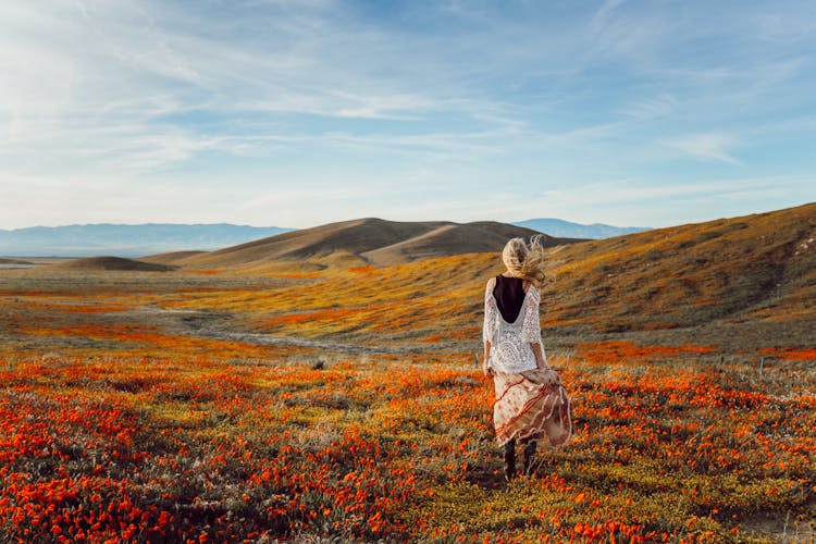 Blonde Person Standing On Flower Field 