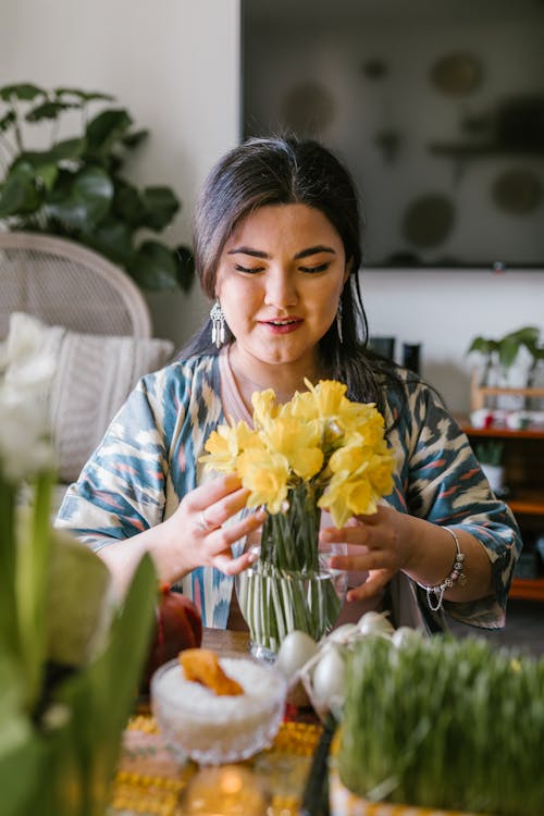 Woman Arranging A Vase With Yellow Flowers