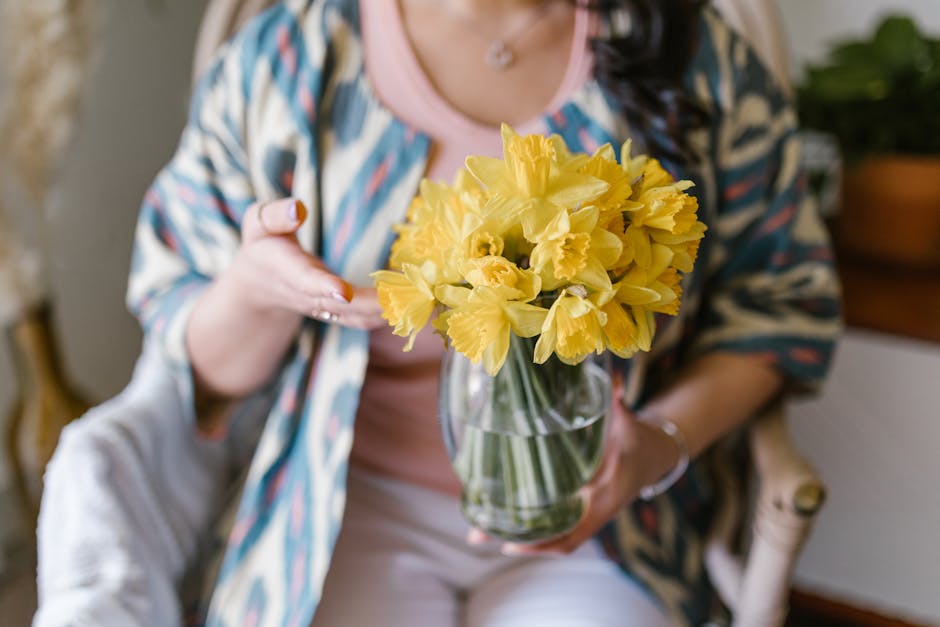 Crop Photo Of Woman Holding A Vase Of Yellow Flowers