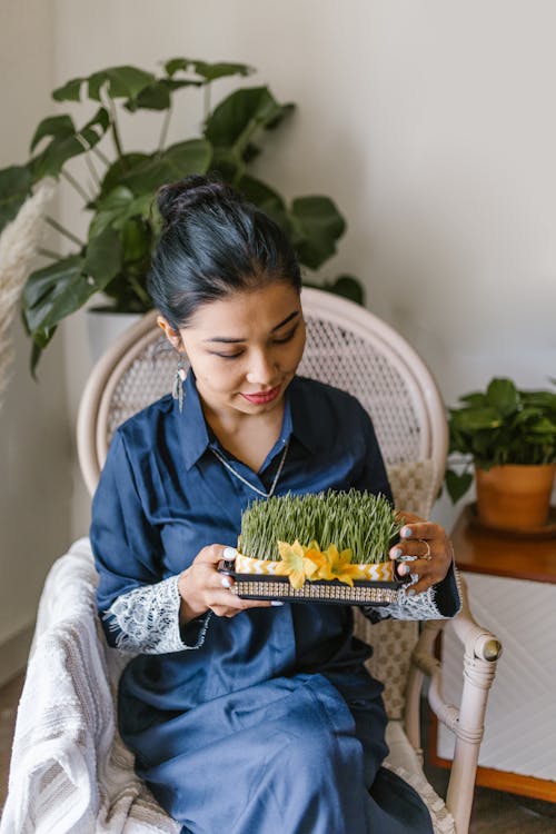 Womfan Holding A Box Of Wheat Sprouts