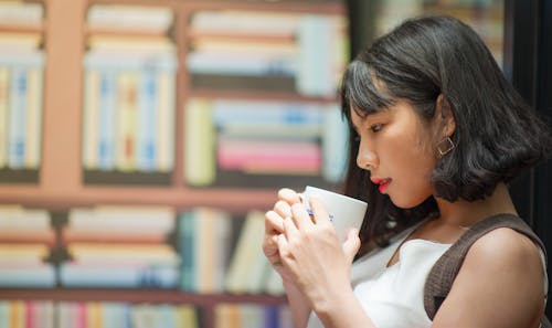 Photography of A Woman Holding White Coffee Mug