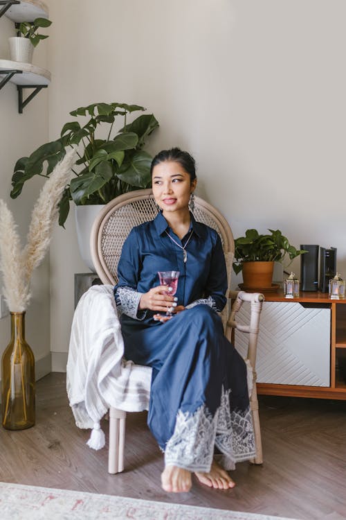 Woman In Blue Dress Holding A Glass Of Wine