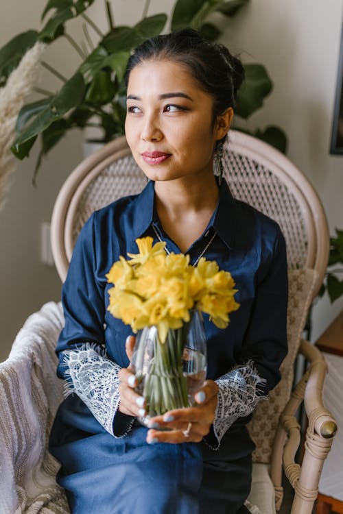 Woman Holding A Vase With Yellow Flowers