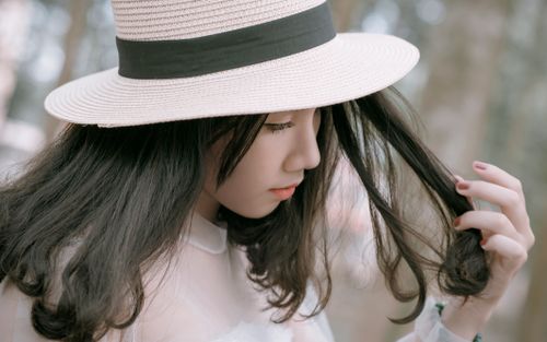 Free Elegant young woman in hat posing outdoors with a serene expression. Stock Photo