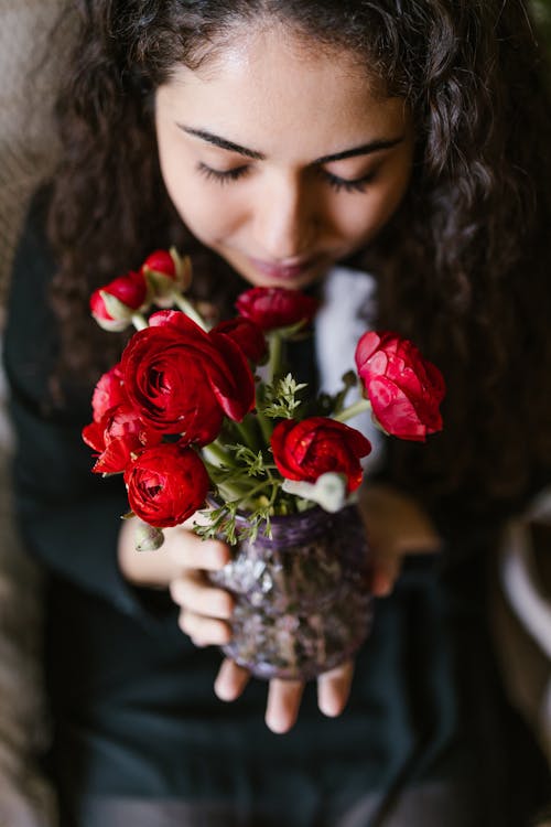 Woman Holding A Vase Of Red Roses
