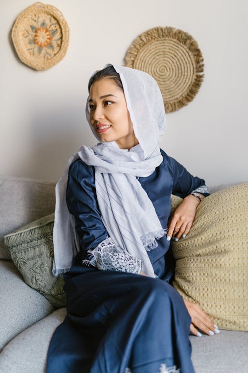 Woman in Blue and White Hijab Sitting on Couch