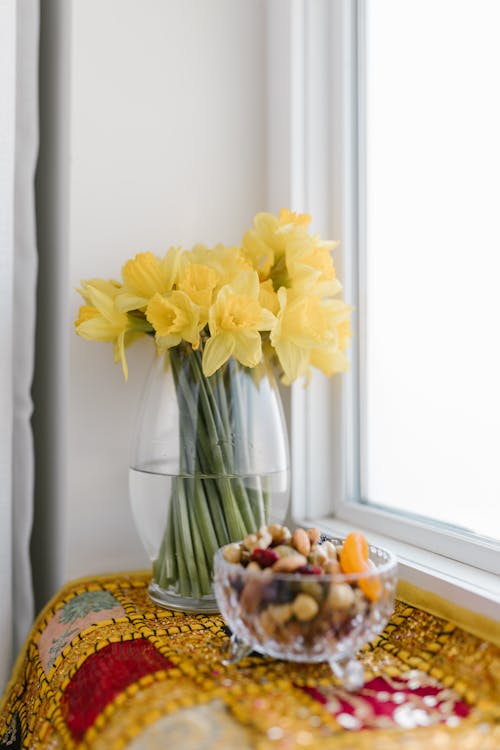 Bowl Of Nuts And Flowers On Table