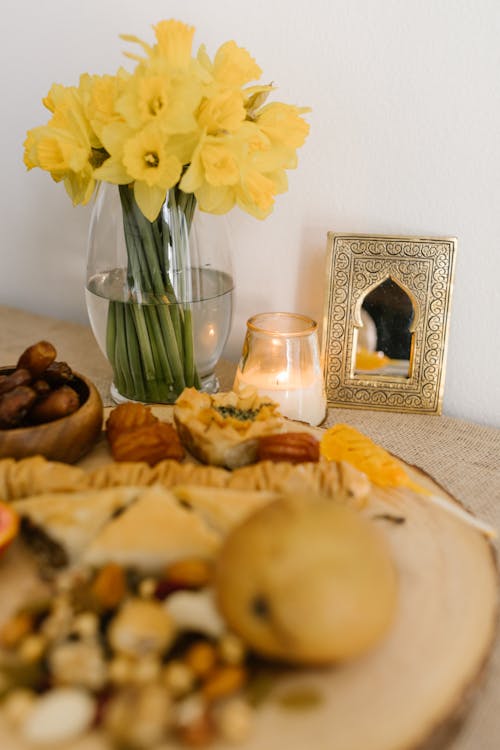 Traditional Food And Yellow Flowers in Clear Glass Vase