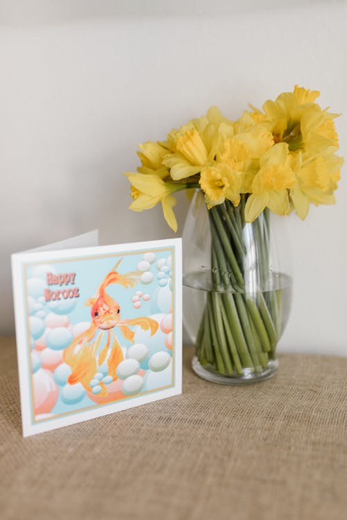 Traditional Card And Glass Vase With Yellow Flowers On Table