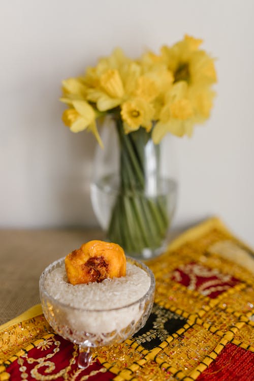 Glass Bowl And Vase With Yellow Flowers On Table