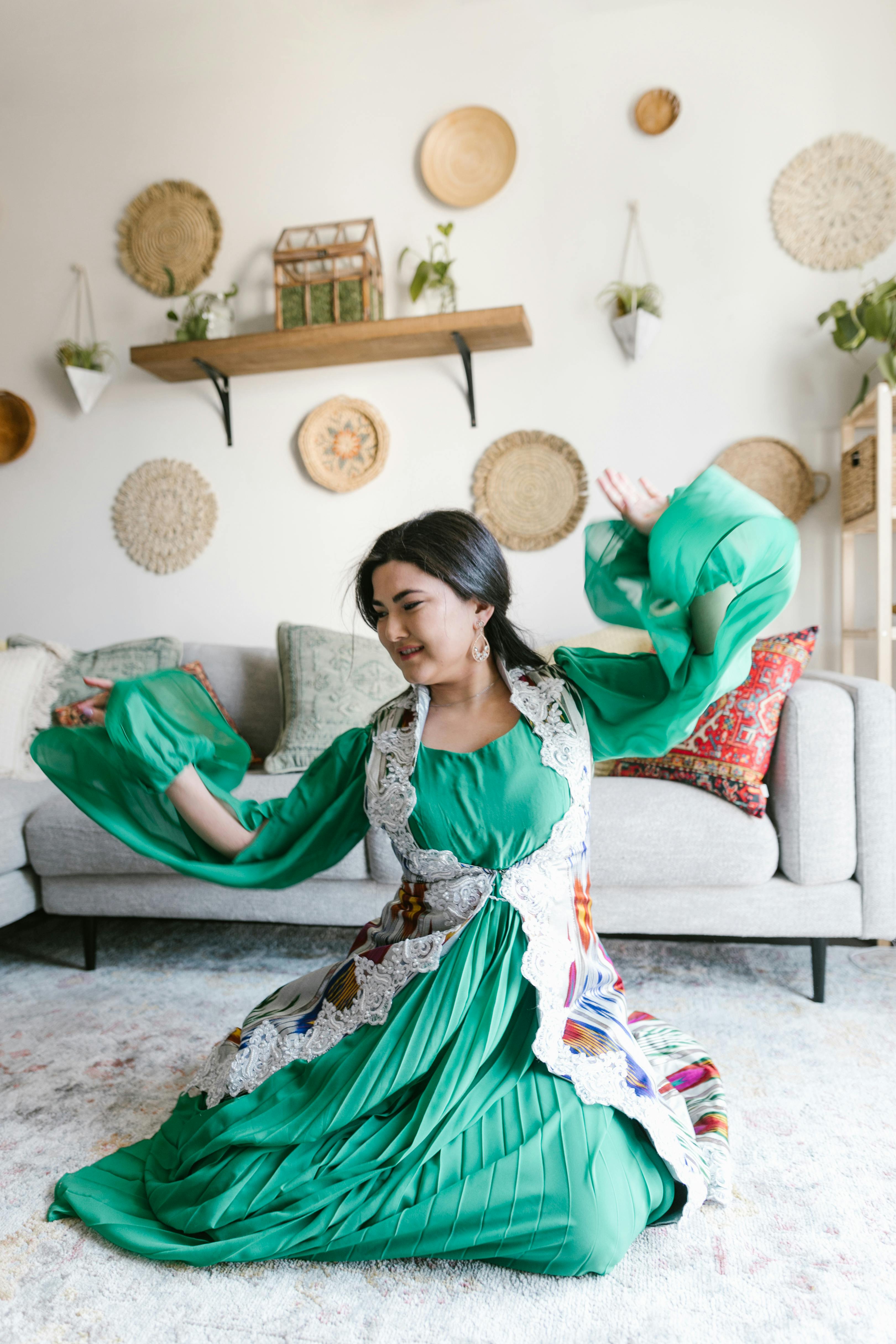 woman in green and white dress sitting on floor and dancing