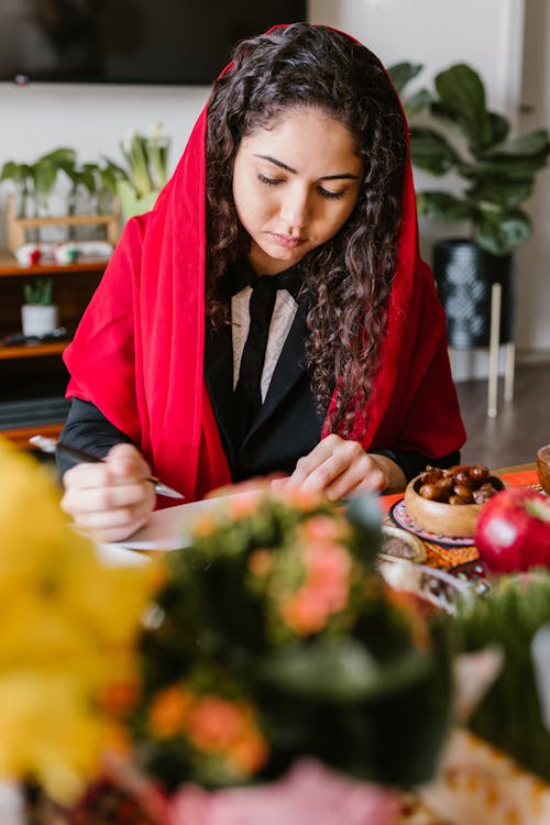 Woman Wearing Red Scarf Writing On Table