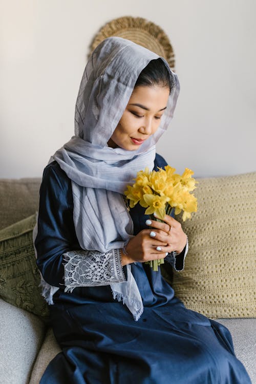 Woman in Blue Hijab Holding Yellow Flower
