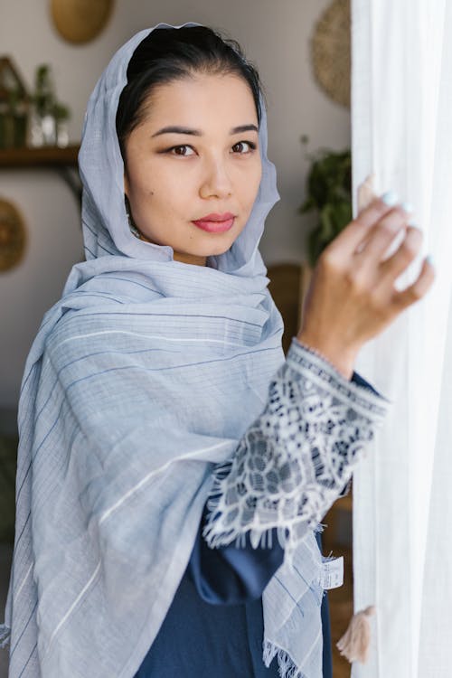 Woman With Blue Hijab Standing Near A Curtain