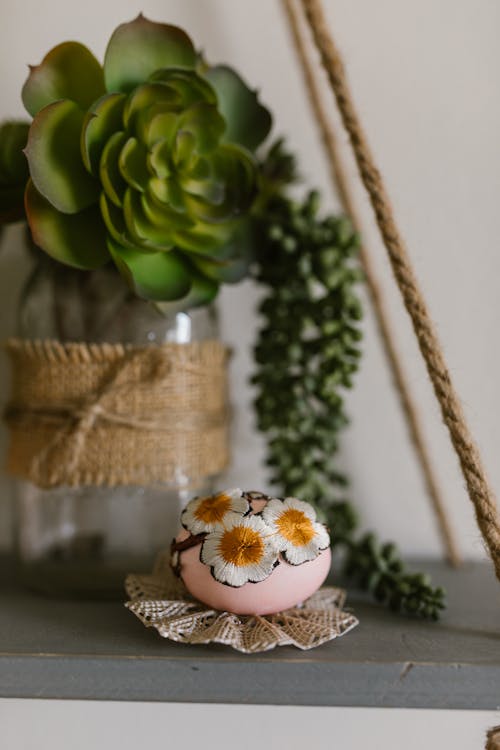 Decorated Egg On Table Beside A Succelent Plant